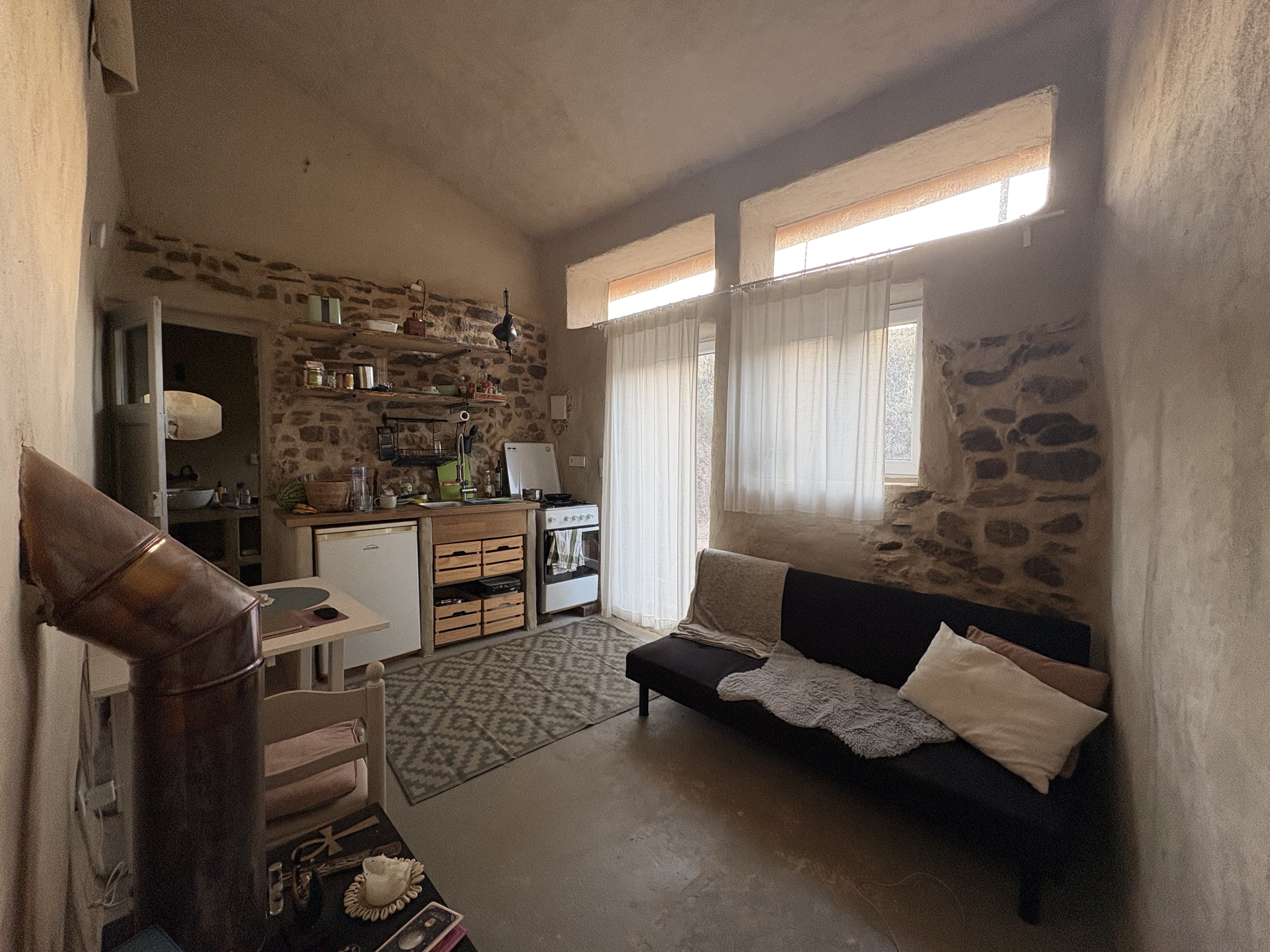 Wohnbereich mit Natursteinwand, Sofa und warmem Licht