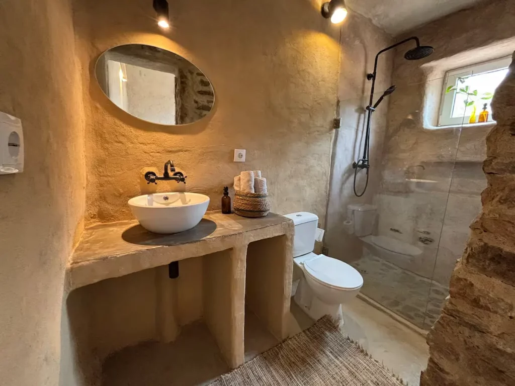 Badezimmer mit rundem Spiegel und Regendusche